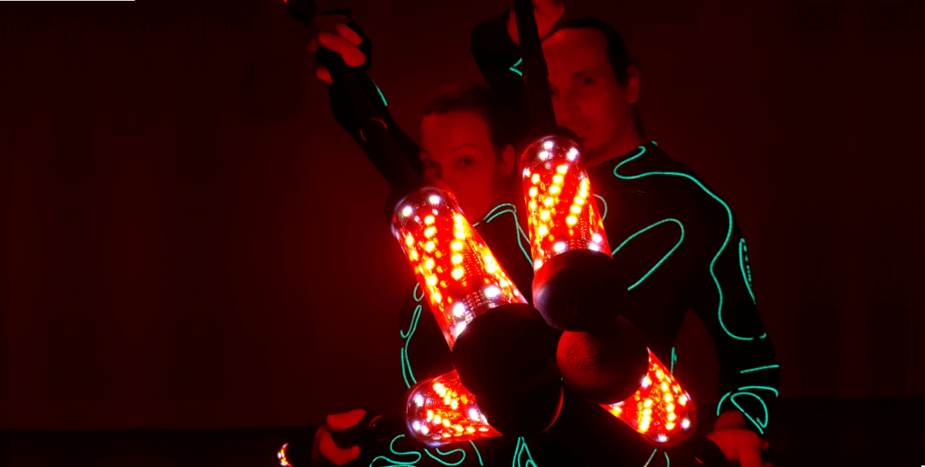 LED Variete Künstler mit Roten Leuchtstäben